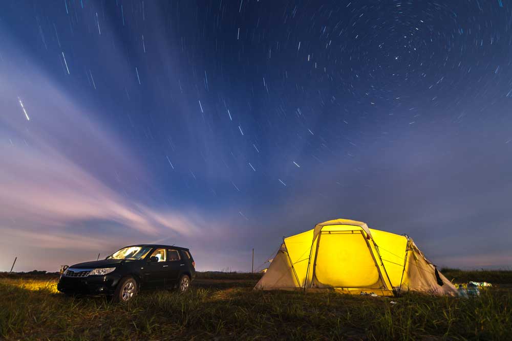 Subaru Forester at beach camping under the night sky