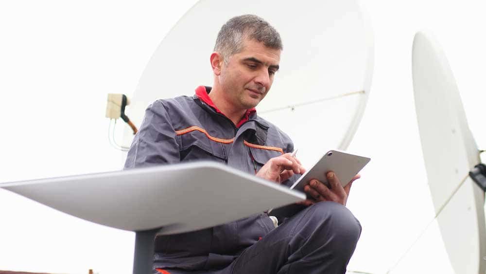 A man installing Starlink dish for fast internet connection