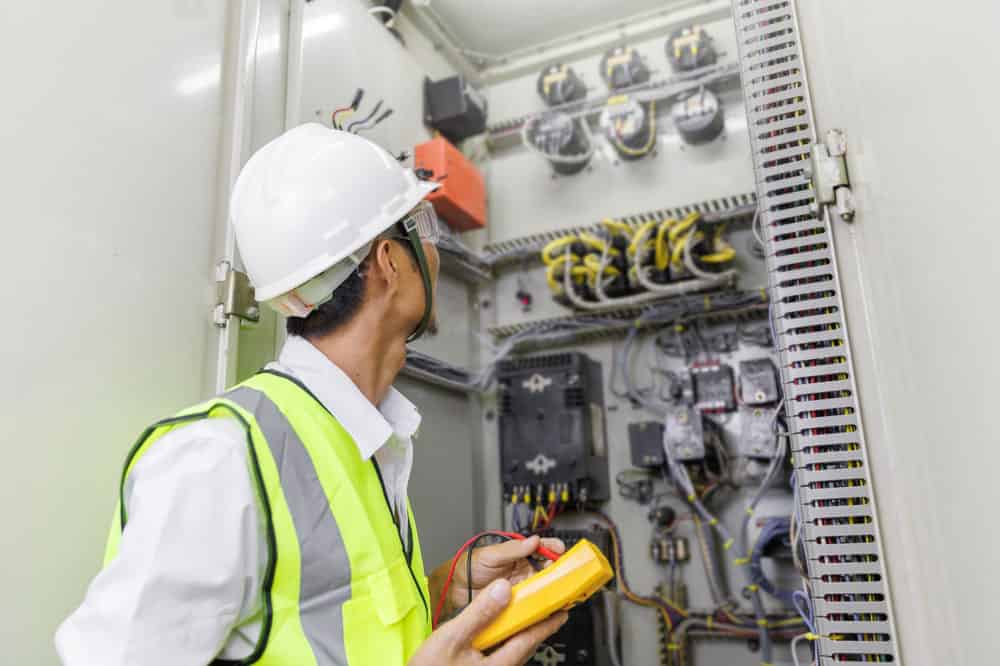 Electrical technician inspecting DC power supply on the grid