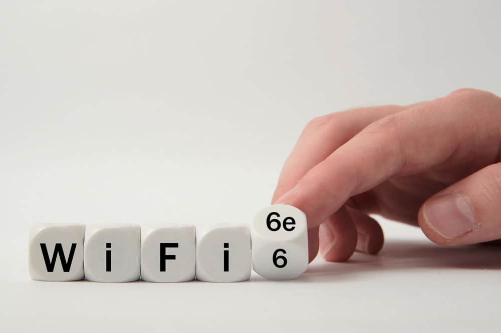 Hand turns dice and changes the expression "WiFi 6" to "WiFi 6e" 